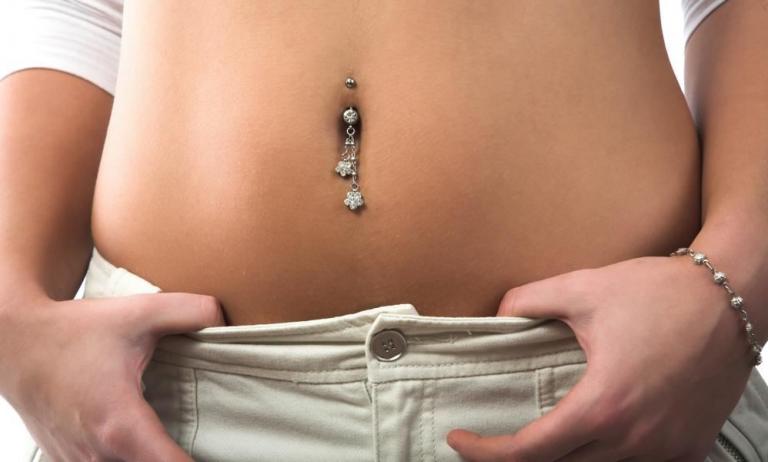Frau trägt größeres Bauchnabel-Piercing